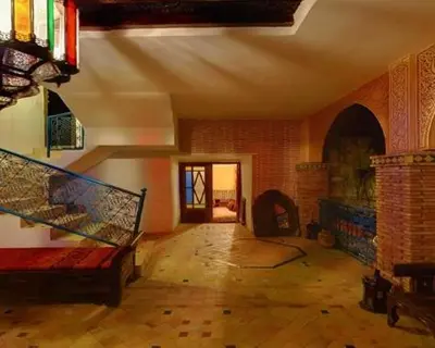 a living room with a couch and a fireplace at Le Riad Meknes in Meknès