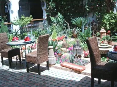 a patio with chairs and a table and a garden at Le Riad Meknes in Meknès