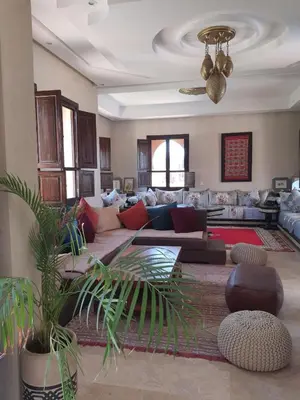 a large living room with couches and a potted plant at Villa Diaf Johanne in Aït Ourir