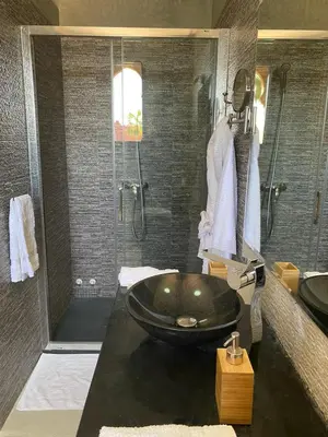 a bathroom with a black tub and a shower at Villa Diaf Johanne in Aït Ourir