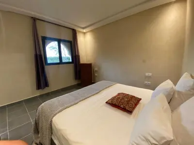 a bedroom with a white bed and a window at Villa Diaf Johanne in Aït Ourir
