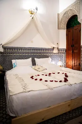 a bedroom with a bed with roses on it at Dar Settash in Fès