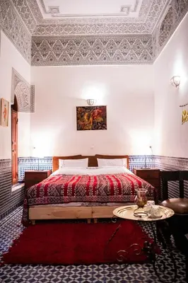 a bedroom with a bed and a table in it at Dar Settash in Fès