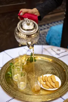 a table with a plate of food and a silver platter with a tea pot at Dar Settash in Fès