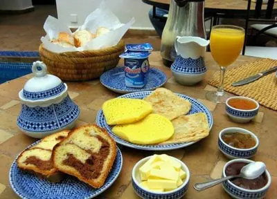 a table topped with plates of bread and cheese at Maison D' hôtes Ait Hmid in Nkob