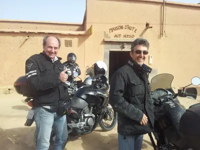 two men are standing in front of a motorcycle at Maison D' hôtes Ait Hmid in Nkob