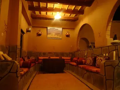 a room with red couches in a building at Maison D' hôtes Ait Hmid in Nkob