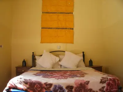 a bedroom with a bed and two towels on the wall at Maison D' hôtes Ait Hmid in Nkob