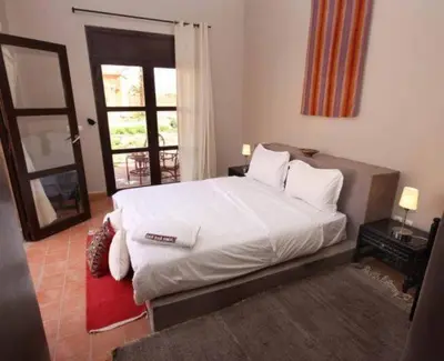 a bedroom with a large white bed and a window at Hotel Bab Rimal - Your Foum Zguid Escape in Foum Zguid