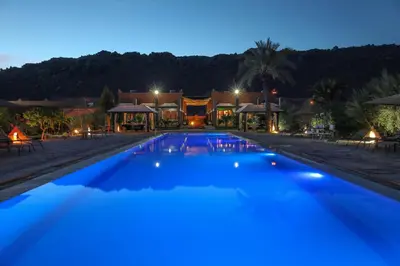 a view of a swimming pool at night at Hotel Bab Rimal - Your Foum Zguid Escape in Foum Zguid