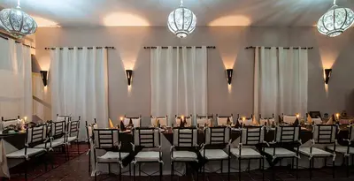 a room with a bunch of tables and chairs at Hotel Bab Rimal - Your Foum Zguid Escape in Foum Zguid