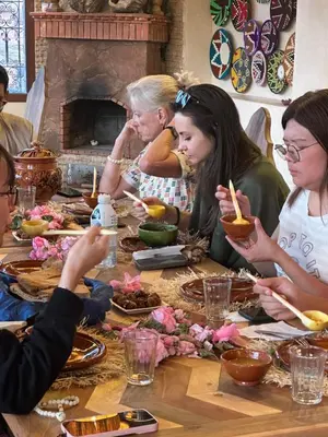 a group of people sitting around a table eating food at Gîte d'étape Tamaloute in Bou Tharar