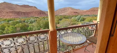 a balcony with a table and a view of mountains at Gîte d'étape Tamaloute in Bou Tharar