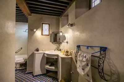 a bathroom with a sink and a toilet and a mirror at Ryad Mabrouka in Fès