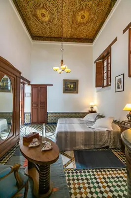 a bedroom with a bed and a table at Ryad Mabrouka in Fès
