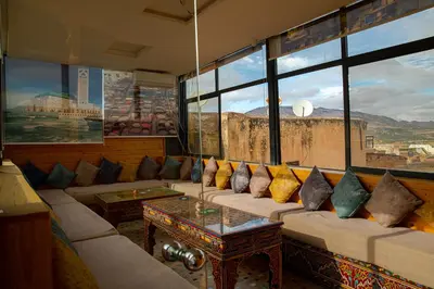 a living room with a couch and a large window at Dar El Yasmine in Fès