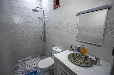 a bathroom with a toilet and a sink with a mirror at Dar El Yasmine in Fès