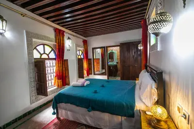 a bedroom with a bed with a blue comforter at Dar El Yasmine in Fès