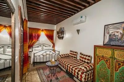 a living room with a couch and two beds at Dar El Yasmine in Fès