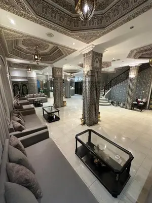 a lobby with couches and a table in a building at Hotel Mounia in Fès