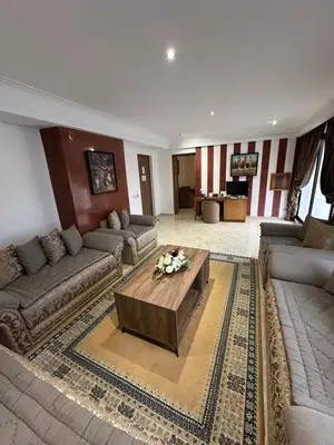 a living room with couches and a coffee table at Hotel Mounia in Fès