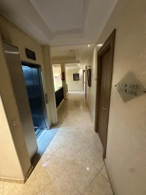 a hallway of a building with a door and a tile floor at Hotel Mounia in Fès