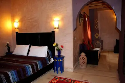a bedroom with a bed and a table with flowers on it at La Kasbah d'Ouzoud in Ouzoud