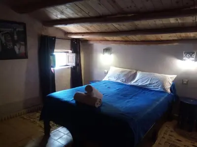 a teddy bear sitting on a bed in a bedroom at La Kasbah d'Ouzoud in Ouzoud