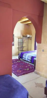 a bedroom with two beds in a room with an archway at La Kasbah d'Ouzoud in Ouzoud