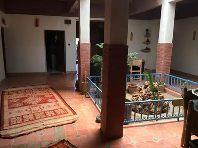 a hallway with columns and a rug in a house at Maison D'hôtes Dar Afra in Aït Ziri