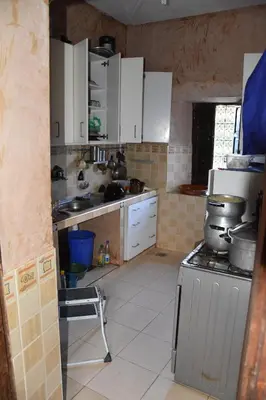 a kitchen with white cabinets and a stove in it at Maison D'hôtes Dar Afra in Aït Ziri