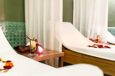 two beds in a room with flowers on a table at Palais Faraj Suites & Spa in Fès
