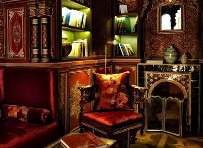 a living room with a chair and a fireplace at Palais Faraj Suites & Spa in Fès