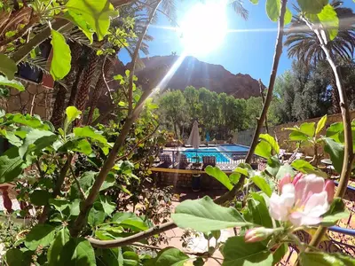 a view from the garden of a resort with a pool at Kasbah Restaurant Amazir in Tinerhir