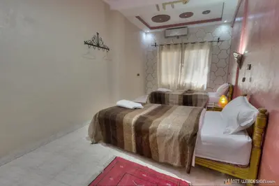 a bedroom with a bed and a window at Kasbah Restaurant Amazir in Tinerhir
