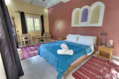 a room with a bed with a white towel on it at Kasbah Restaurant Amazir in Tinerhir