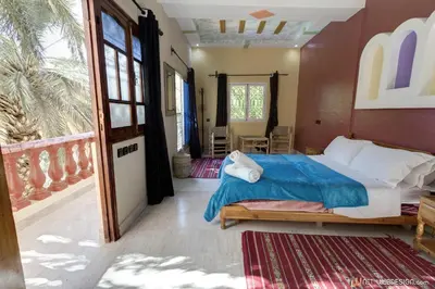 a bedroom with a bed and a large window at Kasbah Restaurant Amazir in Tinerhir