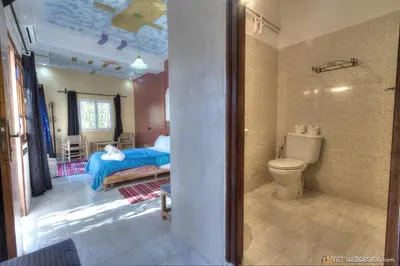 a bathroom with a bed and a toilet in a room at Kasbah Restaurant Amazir in Tinerhir