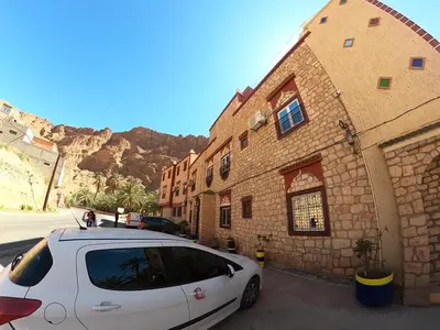 a white car parked in front of a building at Kasbah Restaurant Amazir in Tinerhir
