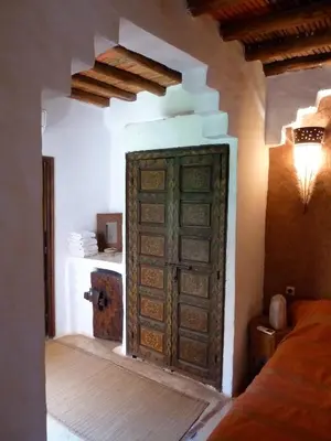 a room with a large wooden door in a bedroom at Riad Cascades d'Ouzoud in Ouzoud