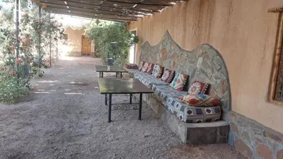 a couch with pillows on it sitting next to a wall at Kasbah Auberge Bassou in Nkob
