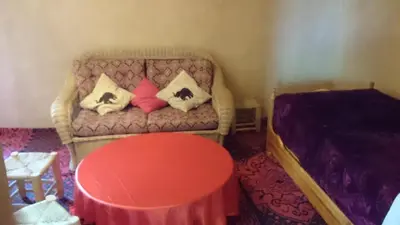 a room with a couch with pillows and a table at Kasbah Auberge Bassou in Nkob