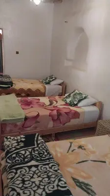 a room with three beds with flowers on them at Kasbah Auberge Bassou in Nkob