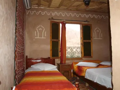 a bedroom with two beds and a window at Maison d'Hôte Valentine in Tinerhir