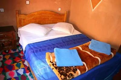 a bed with two blue towels on top of it at Maison d'Hôte Valentine in Tinerhir