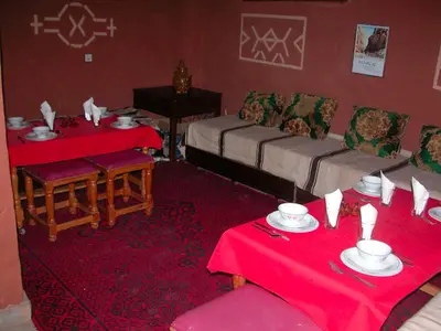a living room with two tables and a couch at Maison d'Hôte Valentine in Tinerhir