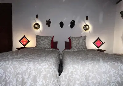 a bedroom with two beds and lights on the wall at Riad Dezayn in Fès