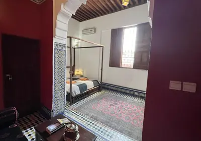a bedroom with a bed and a mirror in a room at Riad Dezayn in Fès