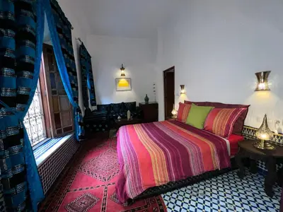 a bedroom with a bed with a colorful blanket at Riad Dezayn in Fès
