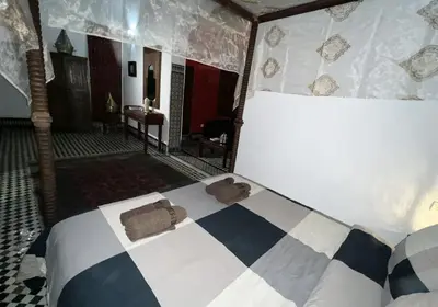 a bedroom with a bed with a checkered bedspread at Riad Dezayn in Fès